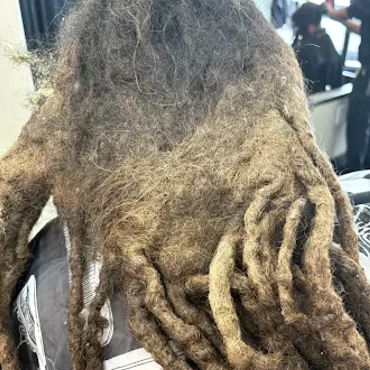 Client's long locs and matted loose hair before loc restoration